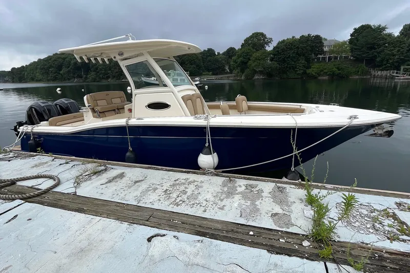 Slide: The Image of 2018 Scout 255 LXF boat docked on a calm lake. - 8