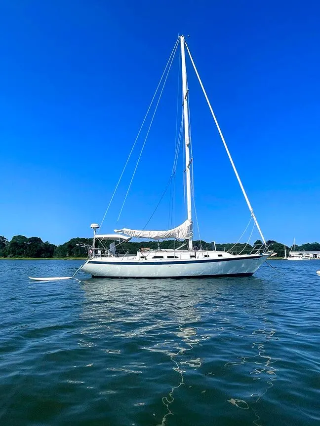 The Image of 1990 Ericson 38-200 sailboat on calm water under clear blue sky. - 0