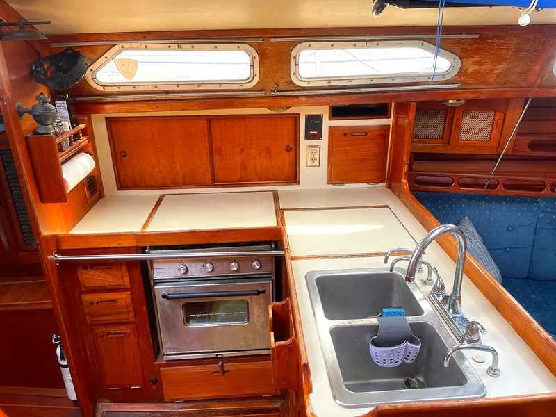 Slide: The Image of Interior of 1990 Ericson 38-200 sailboat kitchen with wood cabinetry and stainless steel sink. - 14