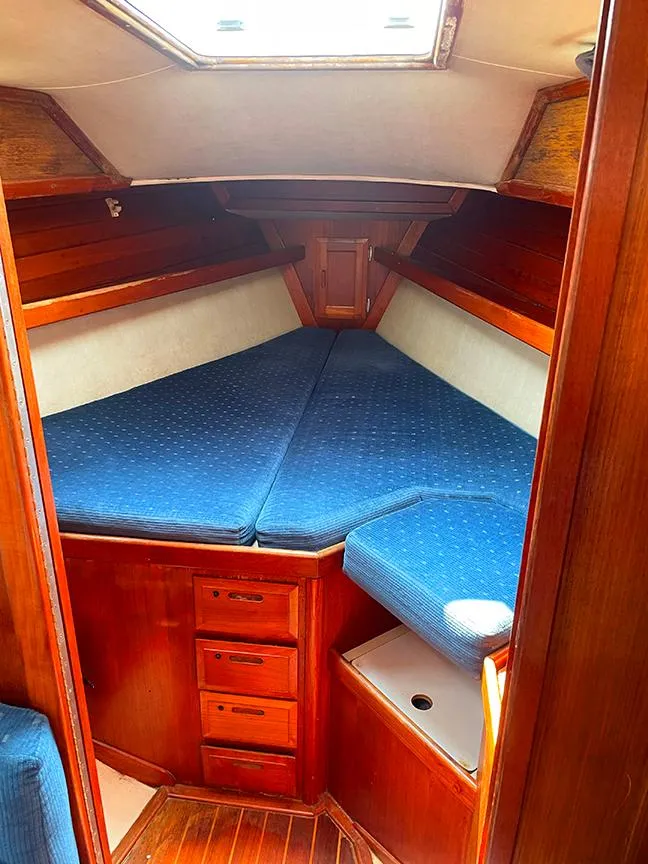 Slide: The Image of Cozy cabin interior of 1990 Ericson 38-200 sailboat with blue cushions and wooden finish. - 16