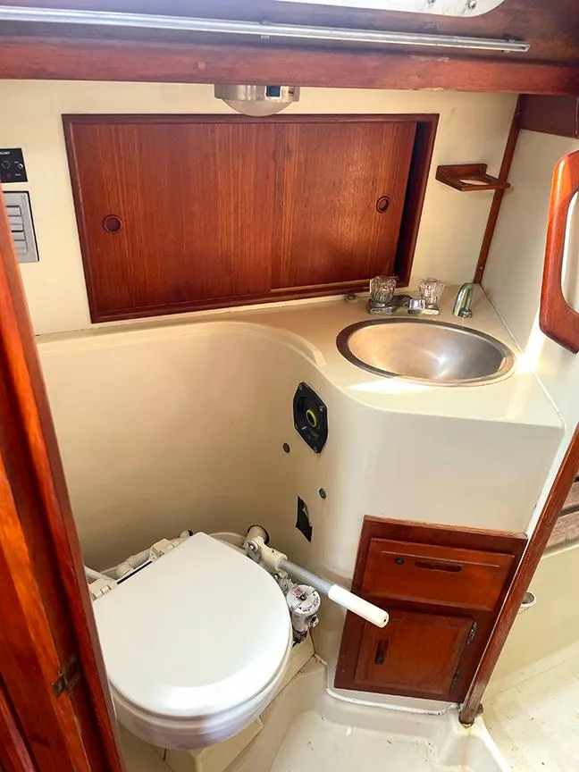 Slide: The Image of 1990 Ericson 38-200 yacht bathroom with sink, toilet, and wooden cabinetry. - 20