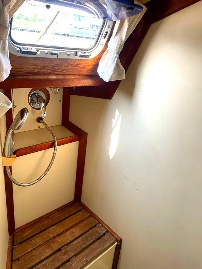 Slide: The Image of 1990 Ericson 38-200 yacht bathroom with wooden accents and a small window. - 21