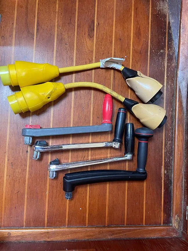 Slide: The Image of Various boat tools and power connectors on wooden surface, Ericson 38-200, 1990 model. - 22