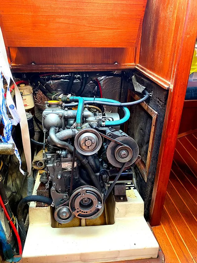 Slide: The Image of Engine compartment of a 1990 Ericson 38-200 sailboat, showcasing mechanical components and wooden interior. - 24