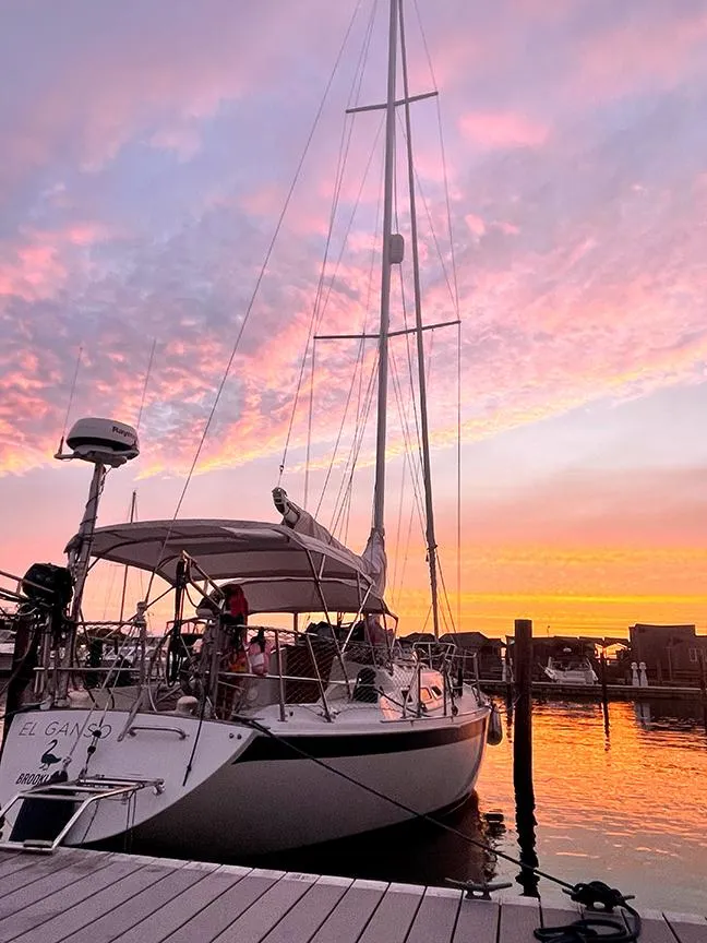 Slide: The Image of Sailboat Ericson 38-200 docked at sunset, vibrant sky reflecting on water. - 25
