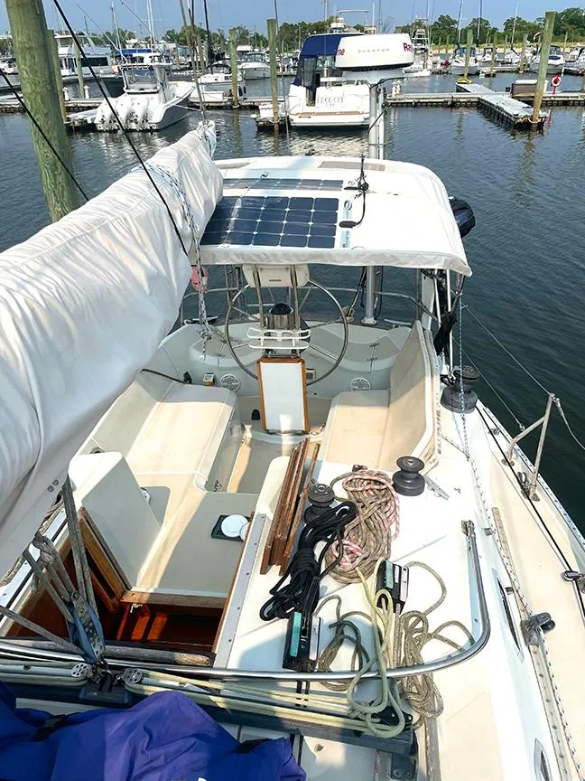 Slide: The Image of 1990 Ericson 38-200 sailboat docked at marina, featuring solar panel and spacious cockpit. - 4