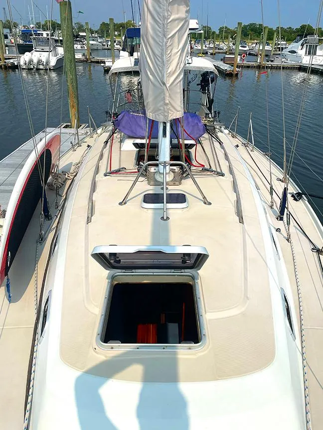 Slide: The Image of 1990 Ericson 38-200 sailboat deck view in marina, showcasing open hatch and rigging. - 6