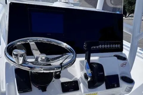 Slide: The Image of 2025 Tidewater 210 CC Adventure boat dashboard with steering wheel and controls. - 2