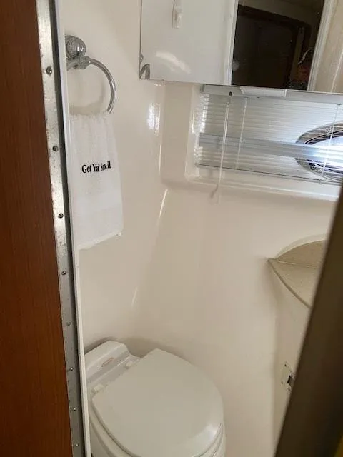 Slide: The Image of 2004 Chaparral Signature 350 bathroom with toilet, towel, and mirror. - 18