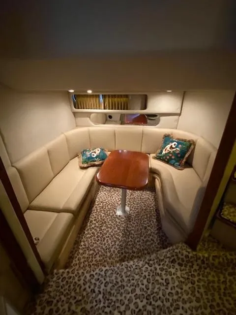 Slide: The Image of 2004 Chaparral Signature 350 cabin with beige seating, wooden table, and patterned carpet. - 22