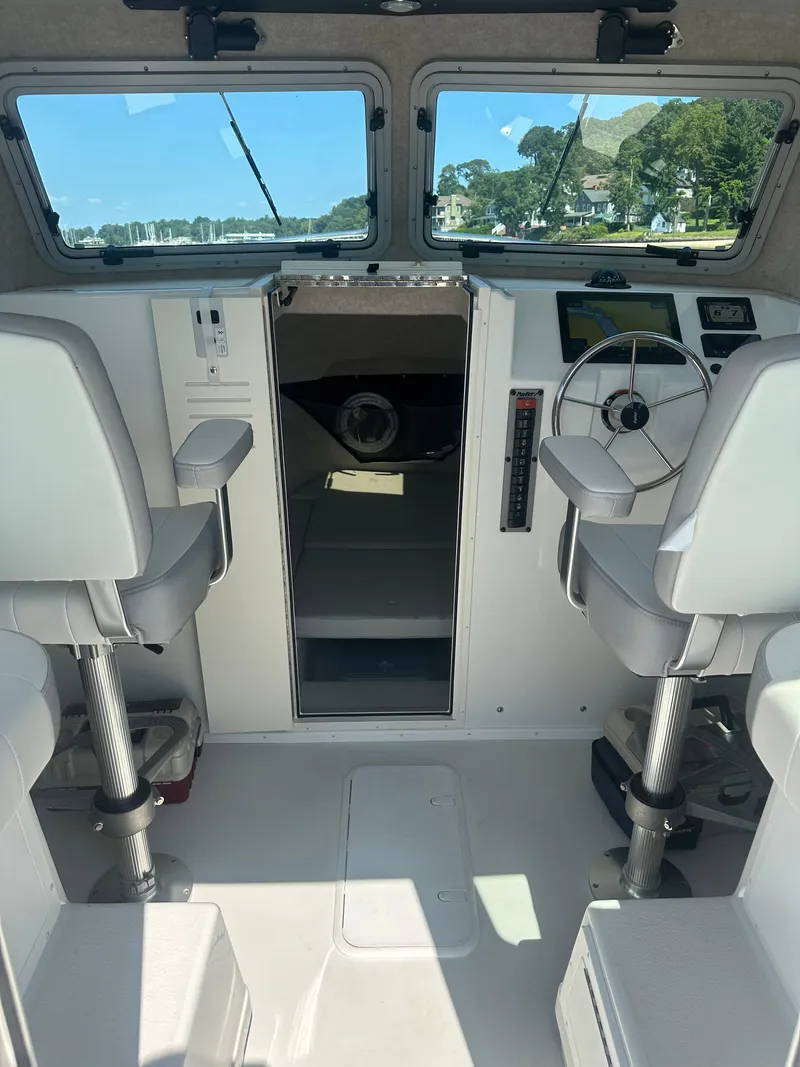 Slide: The Image of Interior of 2022 Parker 2520 XLD Sport Cabin boat with modern controls and seating. - 5