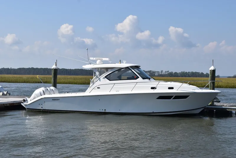 Slide: The Image of 2022 Pursuit OS 355 Offshore boat docked on calm water under a clear sky. - 0