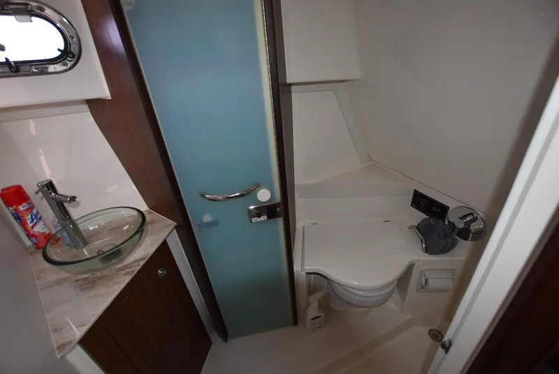 Slide: The Image of 2022 Pursuit OS 355 Offshore bathroom with modern fixtures and glass sink. - 10