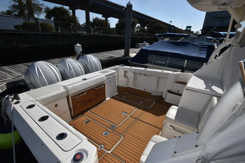 Slide: The Image of 2022 Pursuit OS 355 Offshore boat with spacious deck and triple outboard engines. - 13