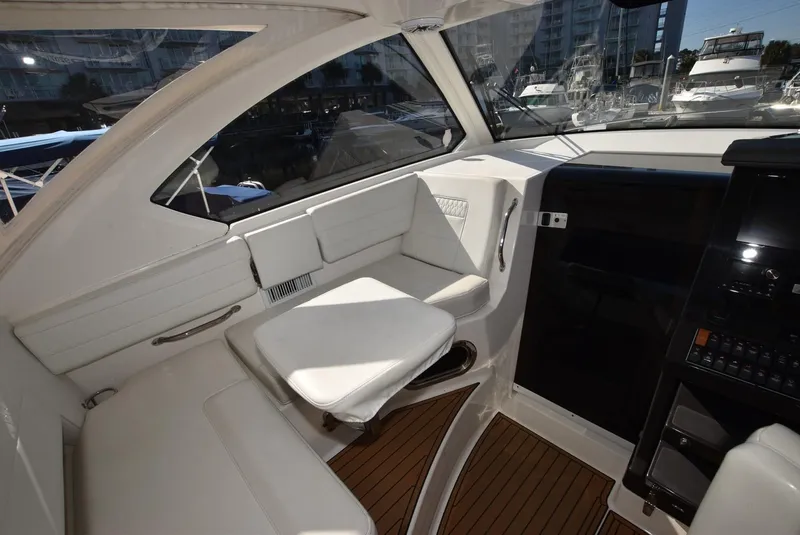Slide: The Image of 2022 Pursuit OS 355 Offshore boat interior with white seating and wood flooring. - 14