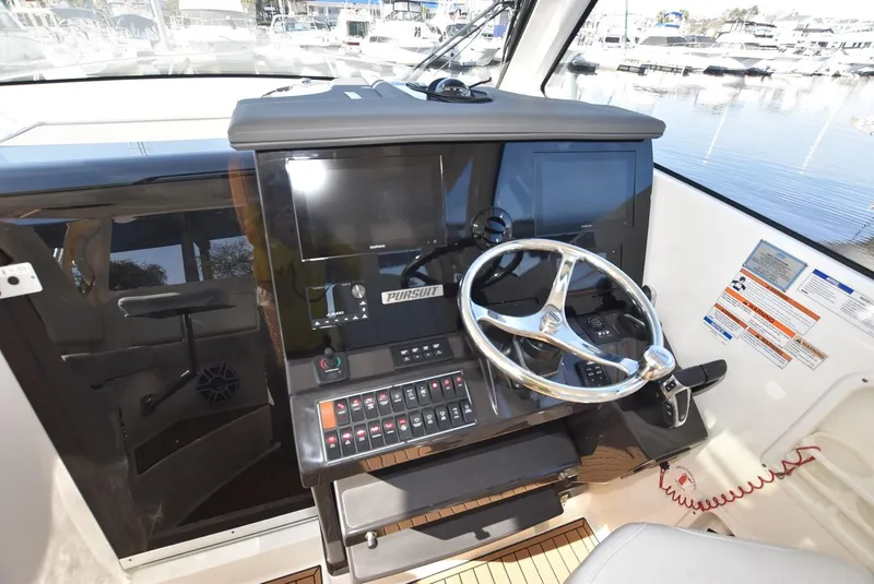 Slide: The Image of 2022 Pursuit OS 355 Offshore helm with steering wheel and control panel. - 15