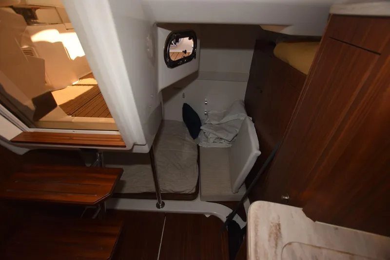 Slide: The Image of 2022 Pursuit OS 355 Offshore cabin interior with wooden finishes and seating area. - 19