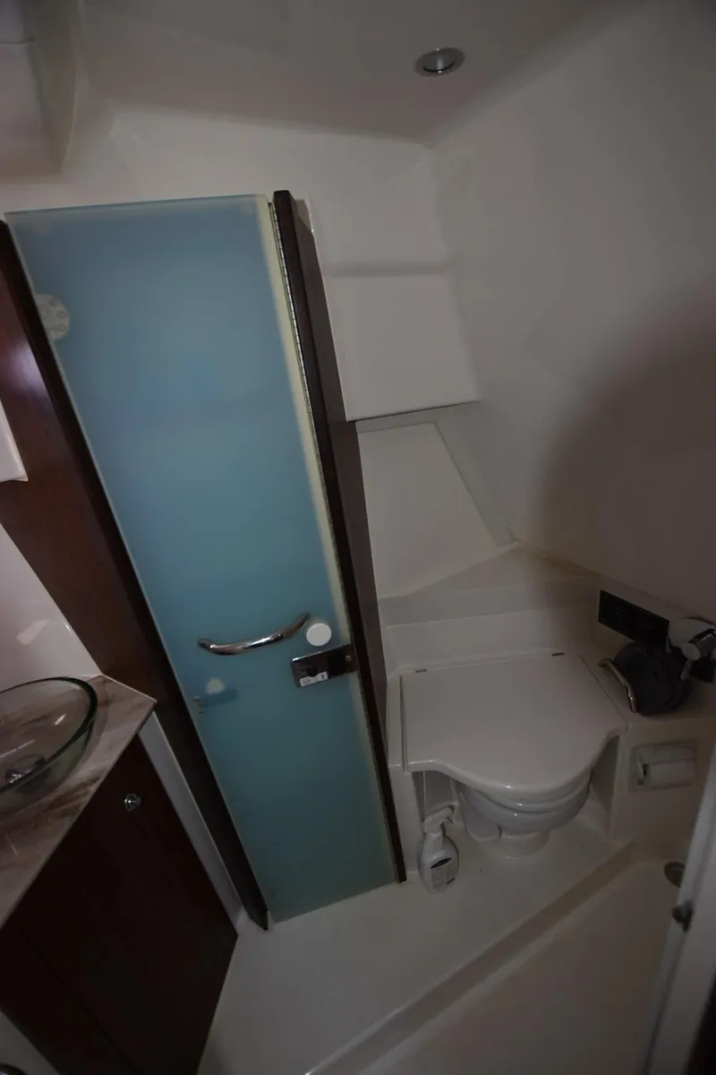 Slide: The Image of 2022 Pursuit OS 355 Offshore bathroom with modern fixtures and frosted glass door. - 25