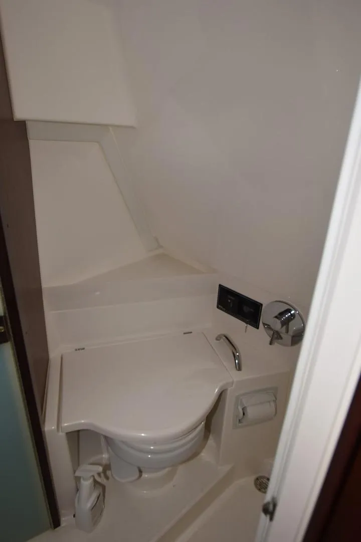 Slide: The Image of 2022 Pursuit OS 355 Offshore boat bathroom with compact toilet and modern fixtures. - 26