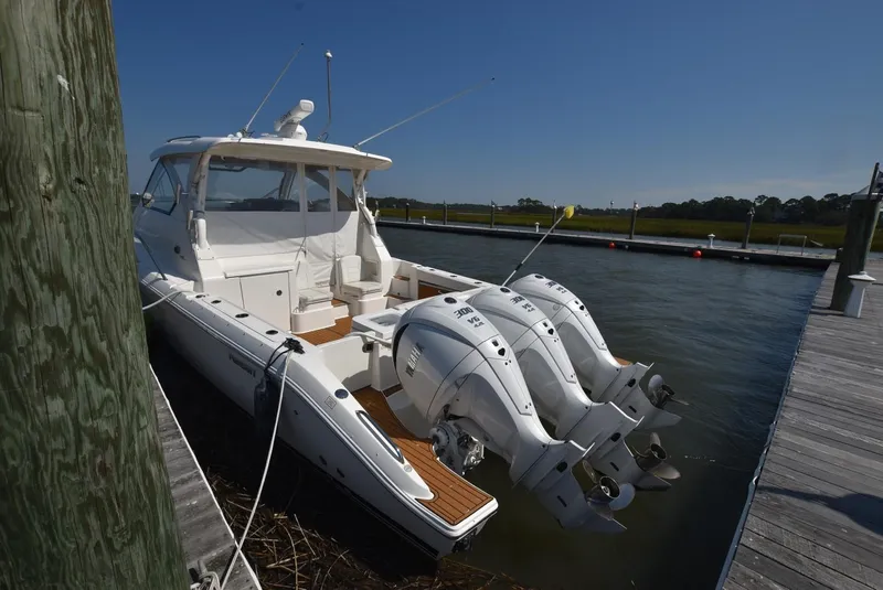 Slide: The Image of 2022 Pursuit OS 355 Offshore boat docked with triple outboard engines. - 5