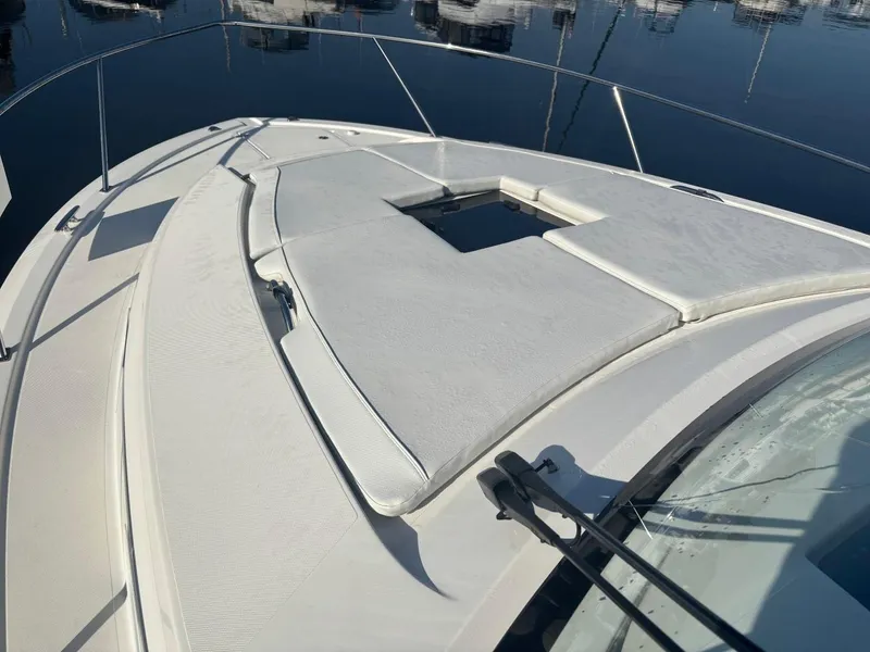 Slide: The Image of 2022 Pursuit OS 355 Offshore boat deck with cushioned seating, docked in marina. - 6