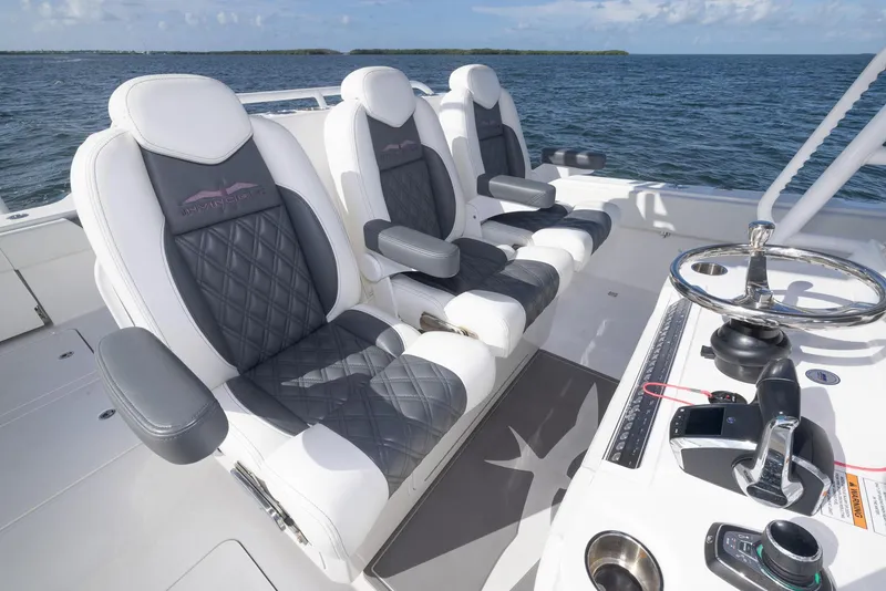 Slide: The Image of 2023 Invincible 35 Catamaran cockpit with luxurious seating and modern controls on open water. - 19
