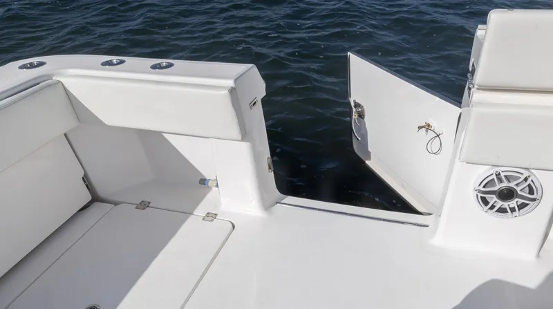 Slide: The Image of 2023 Invincible 35 Catamaran deck with open transom door, white seating, and ocean view. - 28
