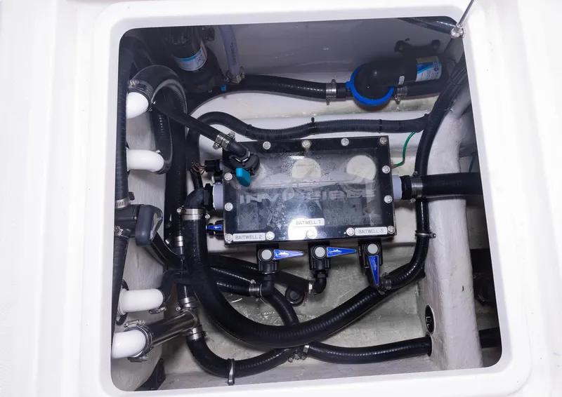 Slide: The Image of Engine compartment of 2023 Invincible 35 Catamaran with visible hoses and components. - 35