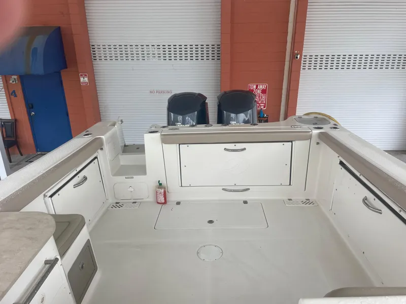 Slide: The Image of 2019 Sailfish 325 Dual Console boat interior with storage compartments and twin engines. - 14