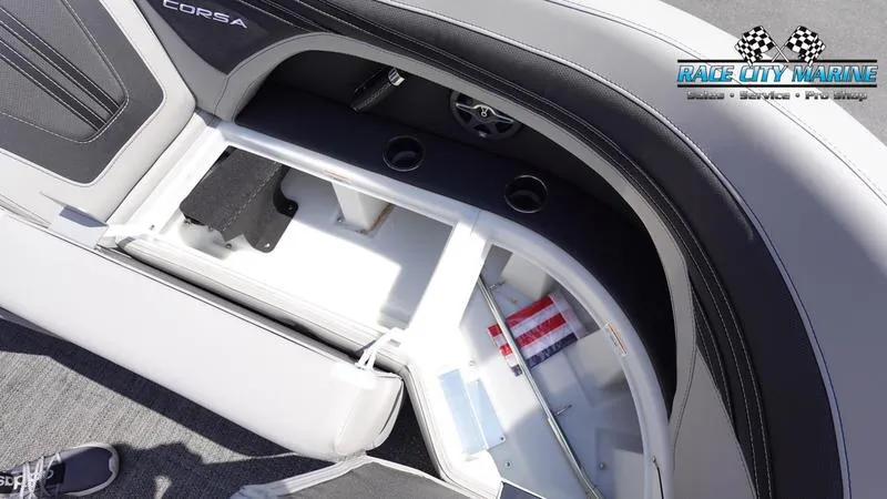Slide: The Image of 2025 Barletta X23U boat interior storage compartment with cup holders and Race City Marine logo. - 11