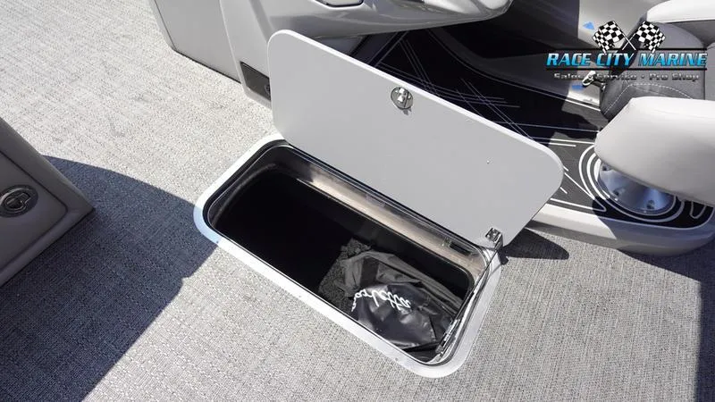 Slide: The Image of 2025 Barletta X23U boat storage compartment with open lid, gray interior. - 22