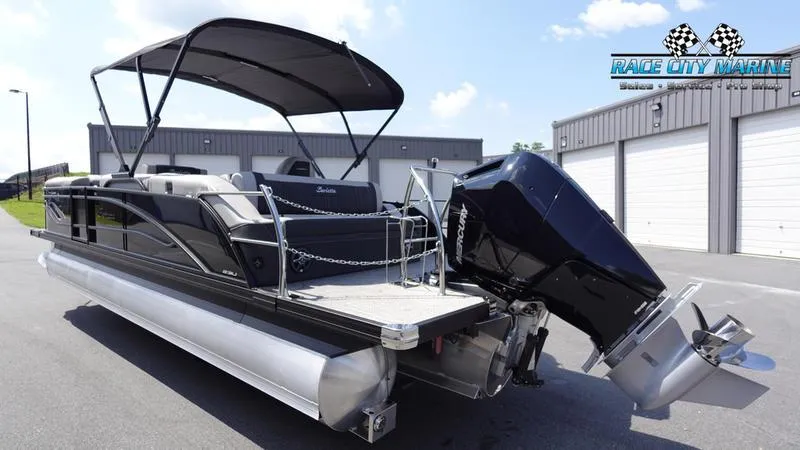 Slide: The Image of 2025 Barletta X23U pontoon boat with canopy and powerful outboard motor, parked at Race City Marine. - 3