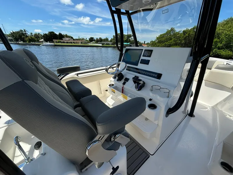Slide: The Image of 2025 Key West 263 FS boat interior with modern helm and seating, overlooking a serene waterway. - 11