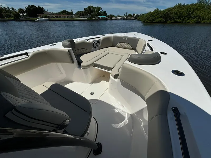 Slide: The Image of 2025 Key West 263 FS boat interior with cushioned seating on a calm waterway. - 13