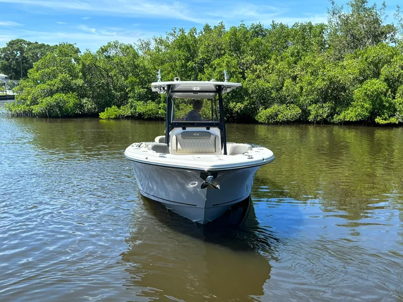 Slide: The Image of 2025 Key West 263 FS boat on calm water, surrounded by lush greenery. - 2