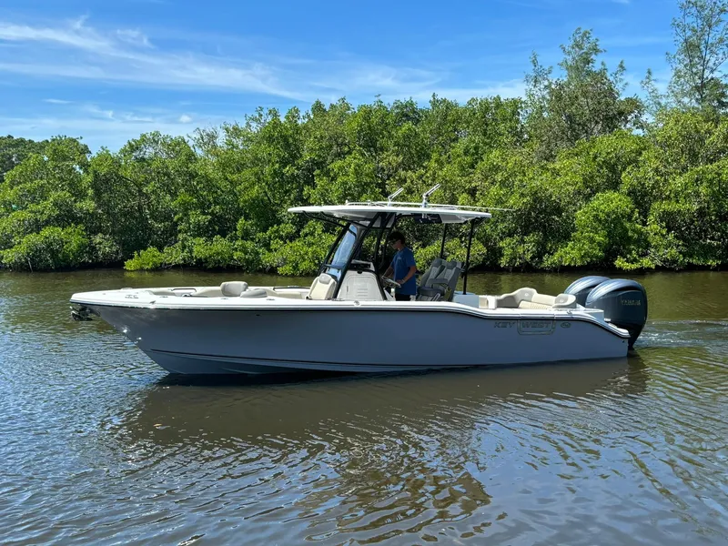 Slide: The Image of 2025 Key West 263 FS boat cruising on a calm river with lush greenery. - 4