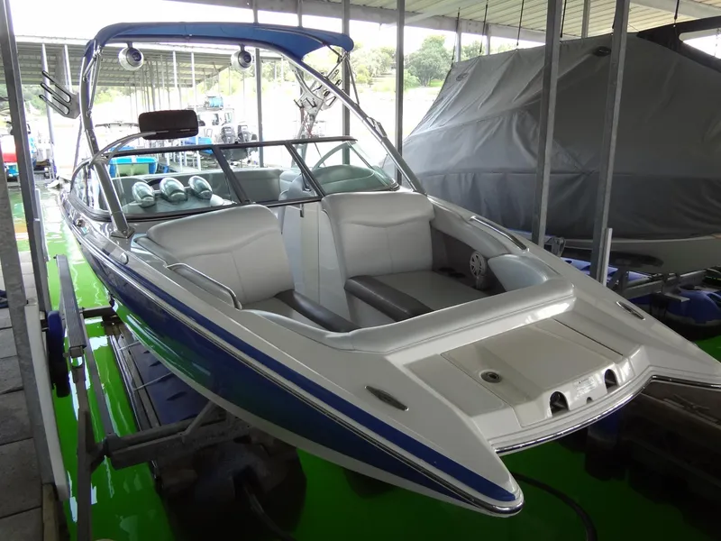 The Image of 2004 MasterCraft X-Star boat with blue and white design in a covered dock. - 0