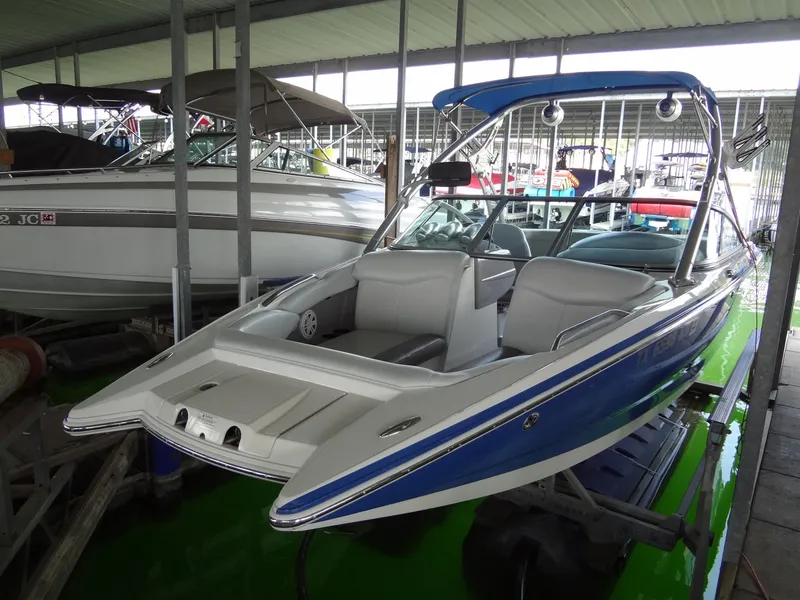 Slide: The Image of 2004 MasterCraft X-Star boat in storage, blue and white exterior, sleek design. - 4
