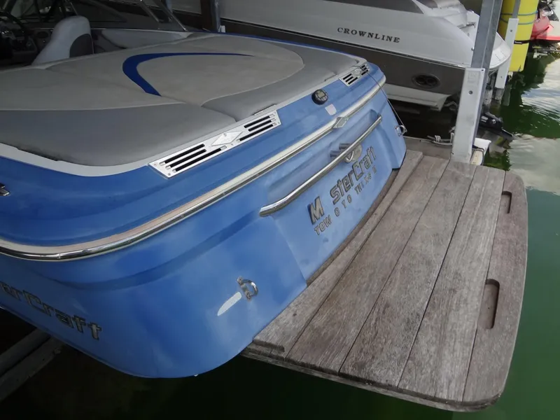 Slide: The Image of 2004 MasterCraft X-Star boat with blue exterior and wooden swim platform. - 5