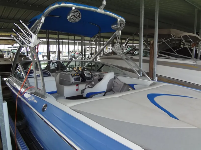 Slide: The Image of 2004 MasterCraft X-Star boat with blue and white interior, docked in a covered marina. - 6