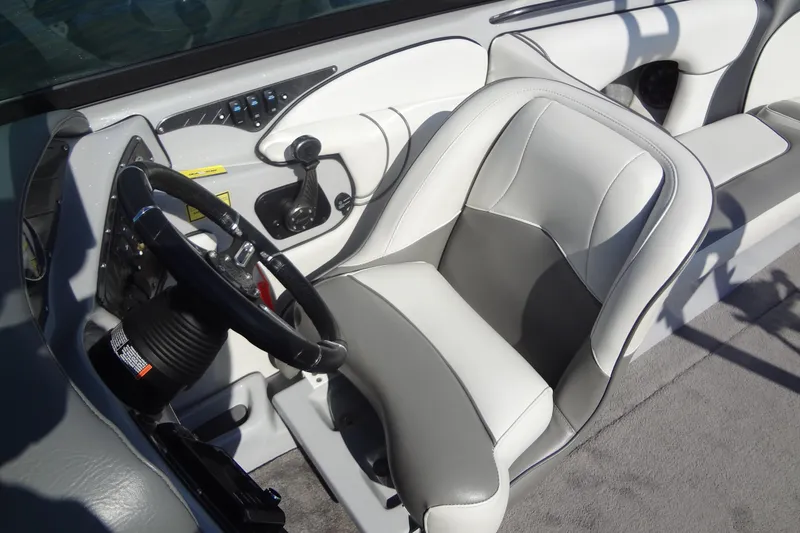 Slide: The Image of Interior of a 2022 Sanger V237 S boat, featuring a sleek steering wheel and comfortable seating. - 10