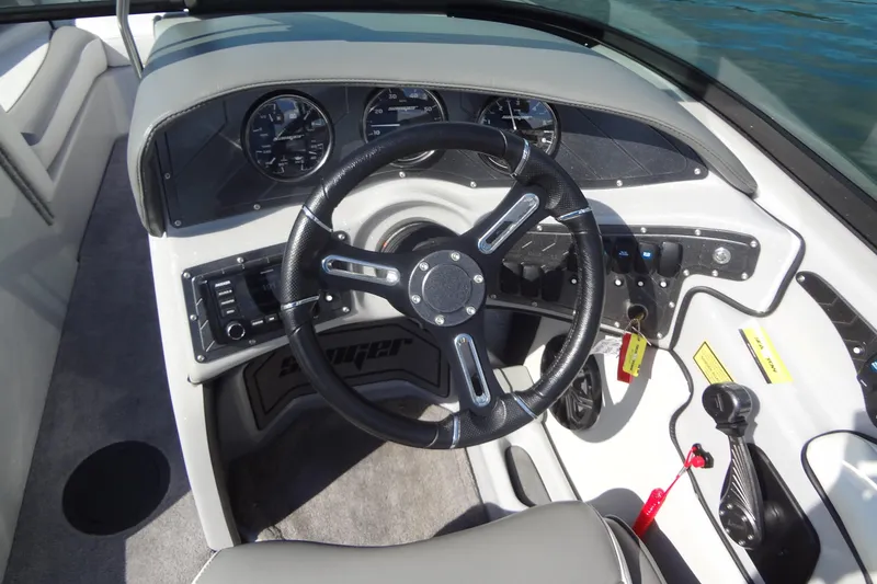 Slide: The Image of 2022 Sanger V237 S boat dashboard with steering wheel and control panel. - 11