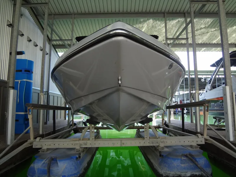 Slide: The Image of 2022 Sanger V237 S boat in storage, front view, under a metal roof. - 24