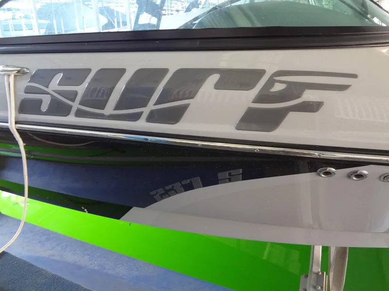 Slide: The Image of 2022 Sanger V237 S boat with "Surf" decal and vibrant green accents. - 27
