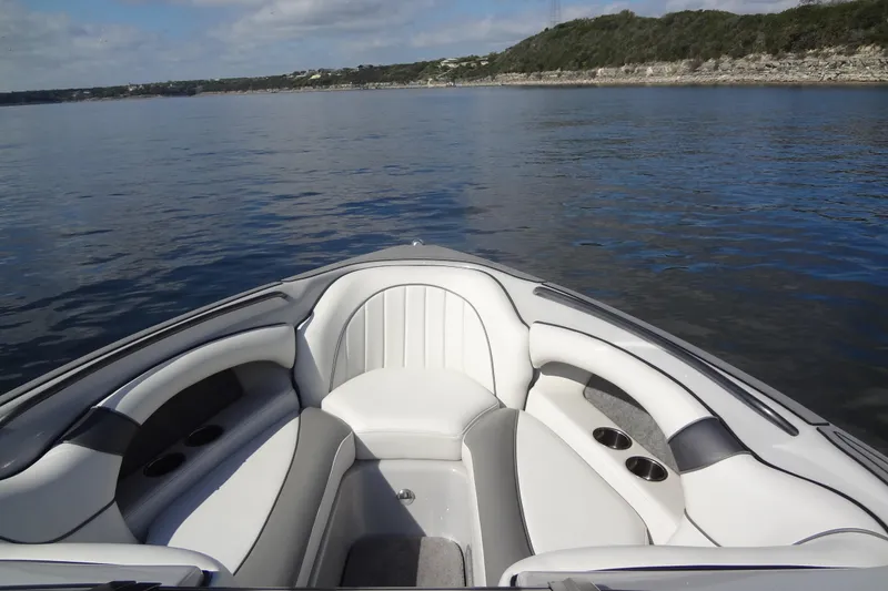 Slide: The Image of 2022 Sanger V237 S boat interior with plush seating on a calm lake. - 4