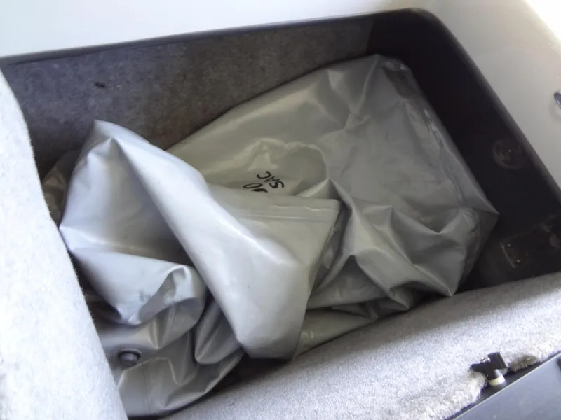 Slide: The Image of Deflated gray boat cover in storage compartment of 2022 Sanger V237 S. - 45