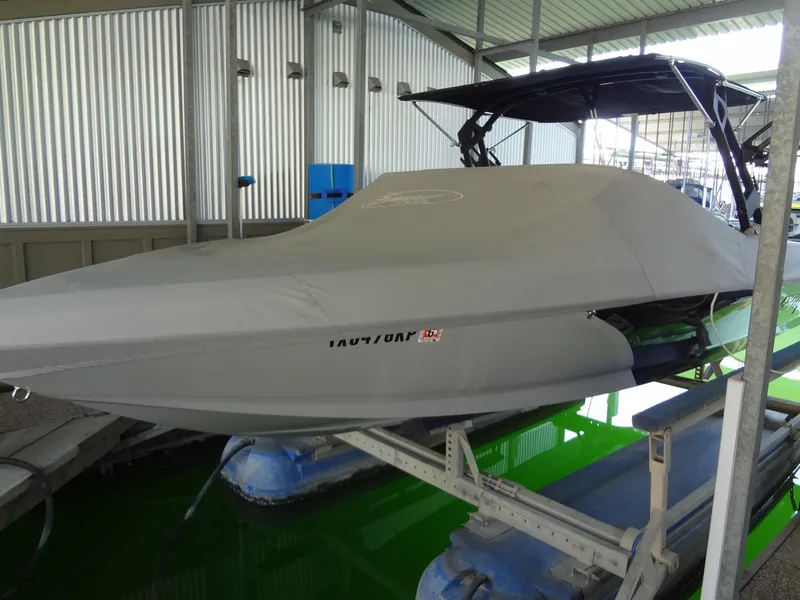 Slide: The Image of 2022 Sanger V237 S boat covered in storage, docked in a marina. - 53