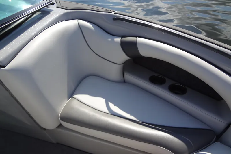 Slide: The Image of 2022 Sanger V237 S boat interior with gray seating and cup holders by the water. - 7