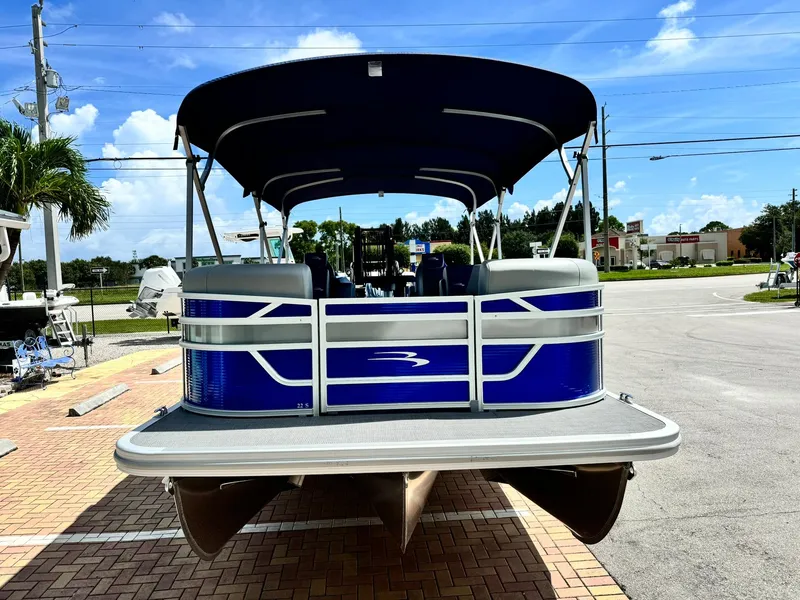 Slide: The Image of 2024 Bennington 22 SSR-SPS pontoon boat with blue exterior, parked on a sunny day. - 2