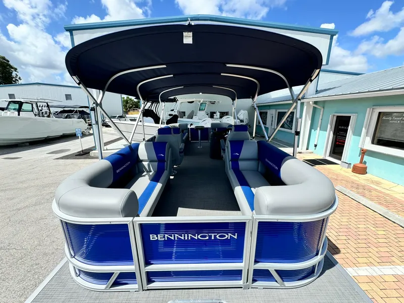 Slide: The Image of 2024 Bennington 22 SSR-SPS pontoon boat with blue and gray seating, docked outdoors. - 8